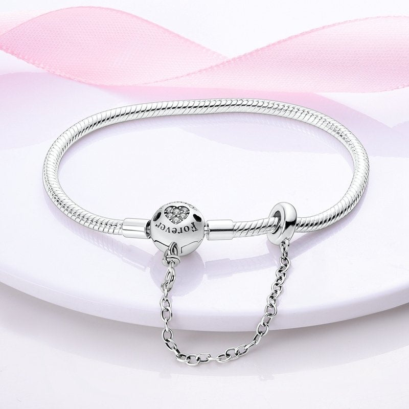 Silver bracelet with a clear gemstone on a pink fabric background