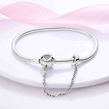 Silver bracelet with a clear gemstone on a pink fabric background